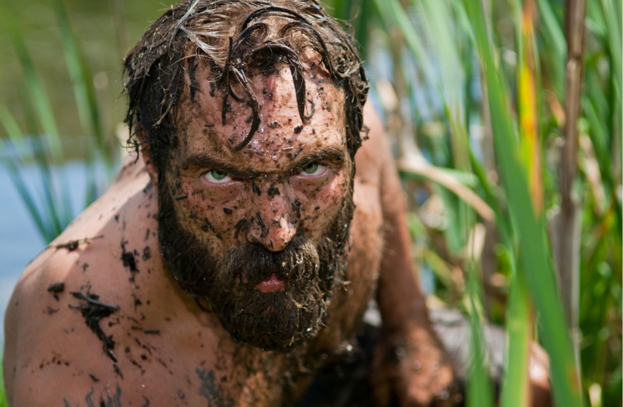 Ein Mann steigt aus einem Sumpf.